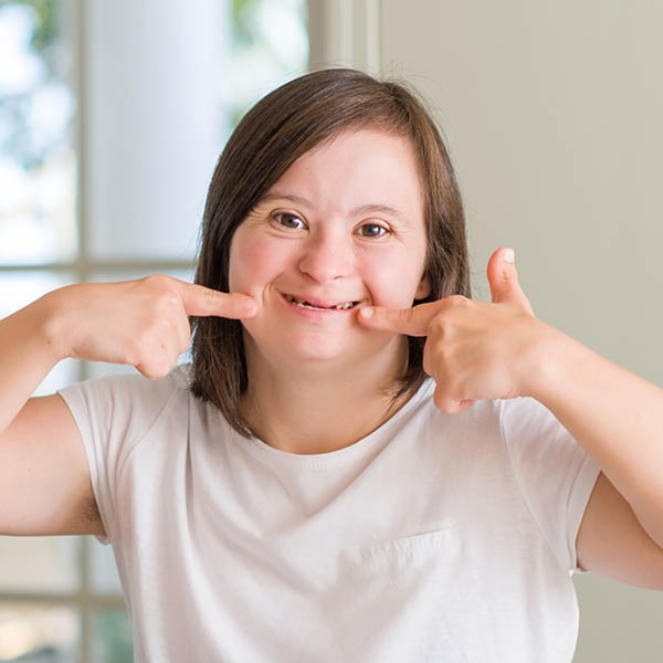 Young special woman pointing to her broad smile