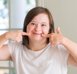 Young special woman pointing to her broad smile
